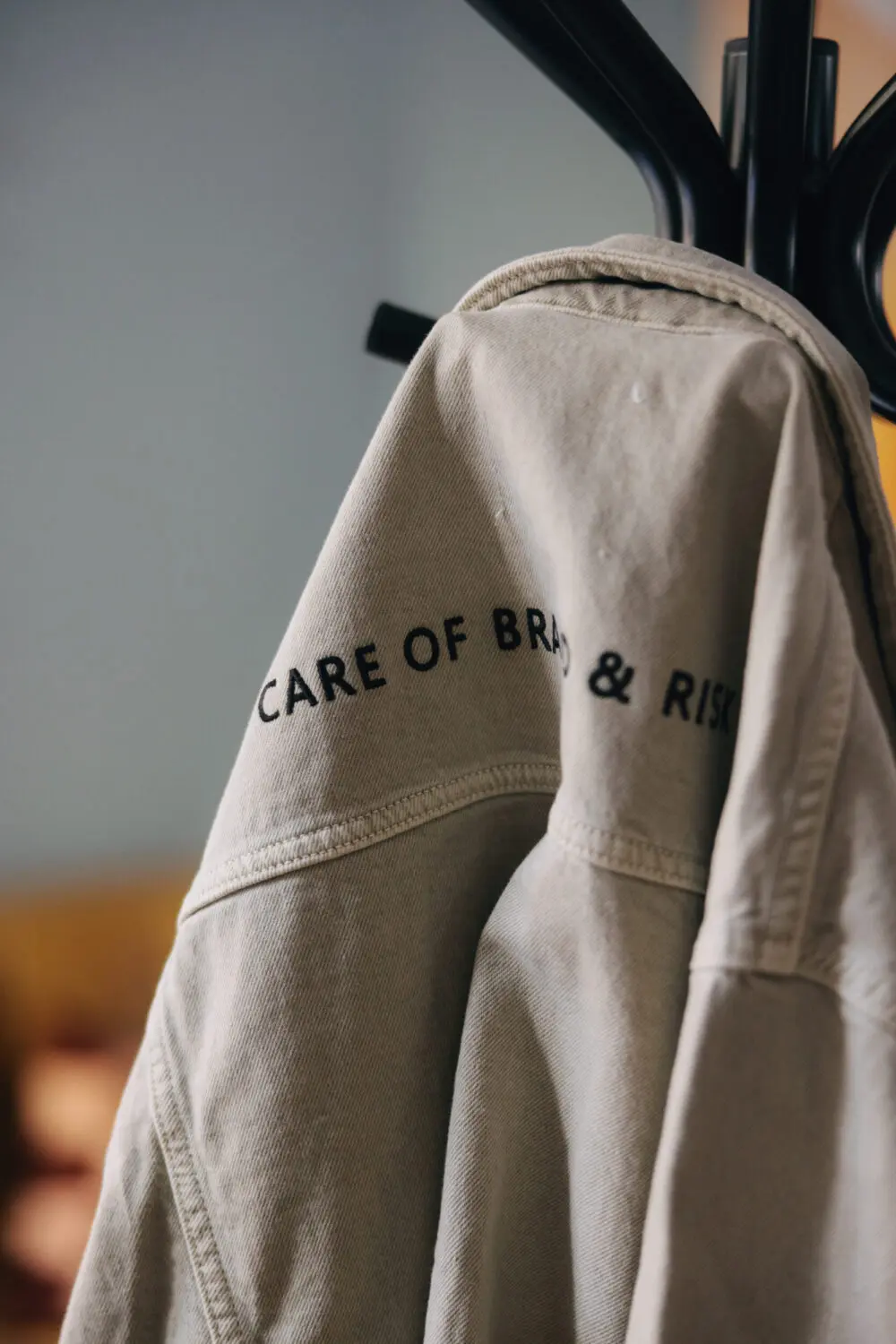 Ryggtavla med "Care of Brand & Risk" på jackan.